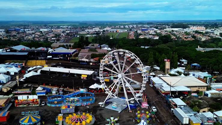 Vista aérea do parque de exposições de Londrina com tendas brancas, roda-gigante e estruturas temporárias