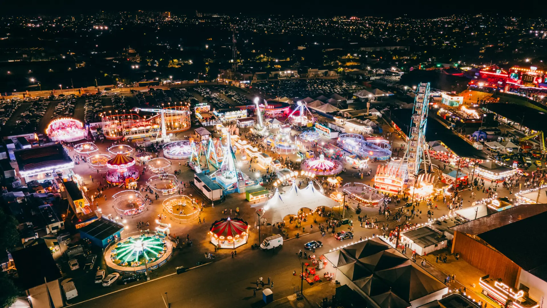 Vista aérea noturna do parque de exposições iluminado durante grande feira agropecuária