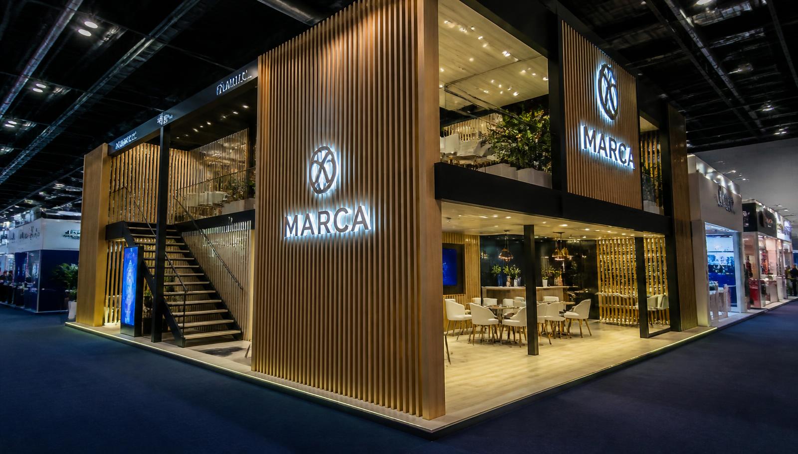 Stand construído de dois pavimentos com ripado de madeira, letra caixa iluminada e lounge de reuniões em feira de São Paulo