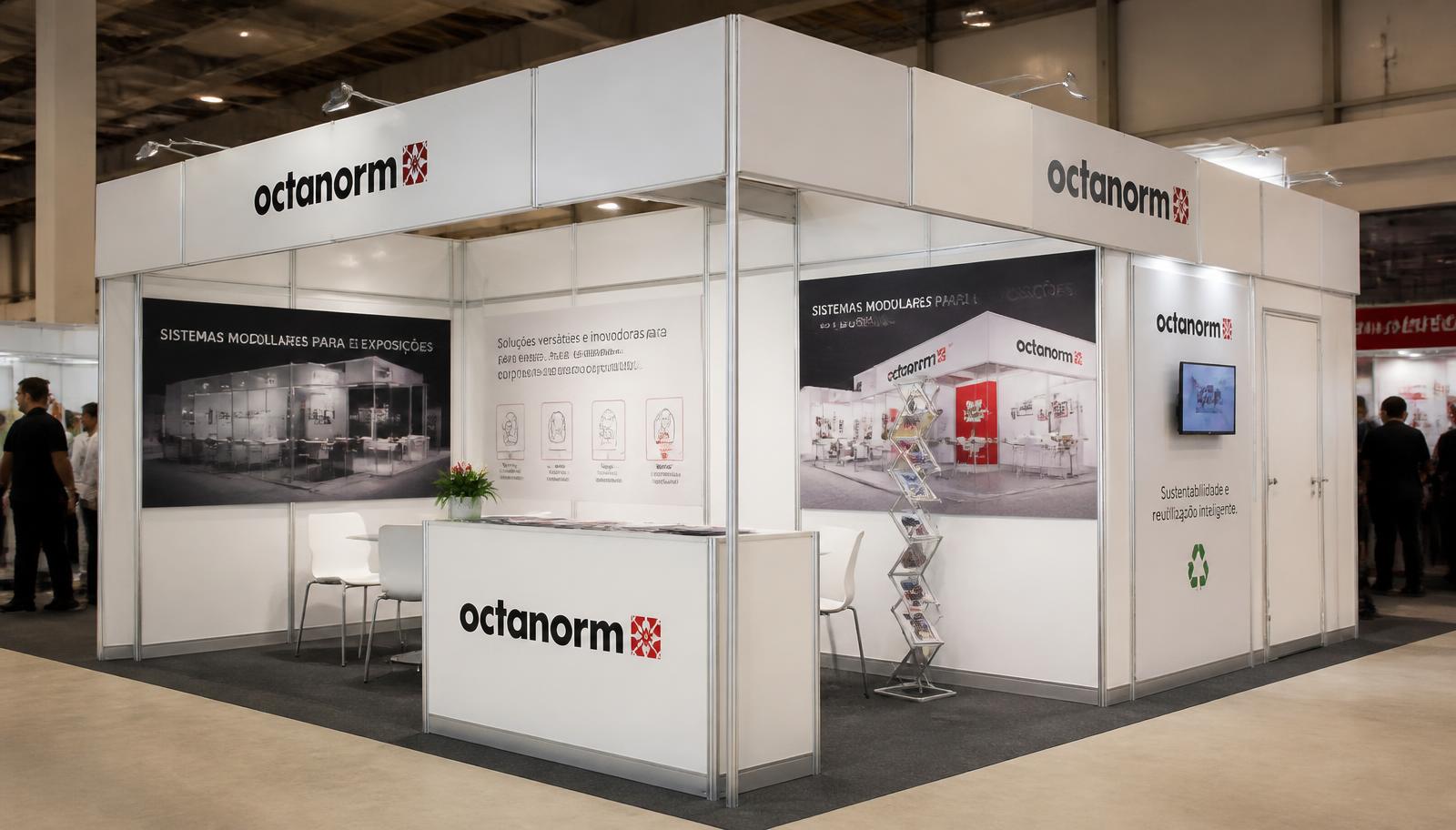 Stand modular branco em sistema Octanorm com balcão, painéis gráficos e mesa de atendimento em pavilhão brasileiro